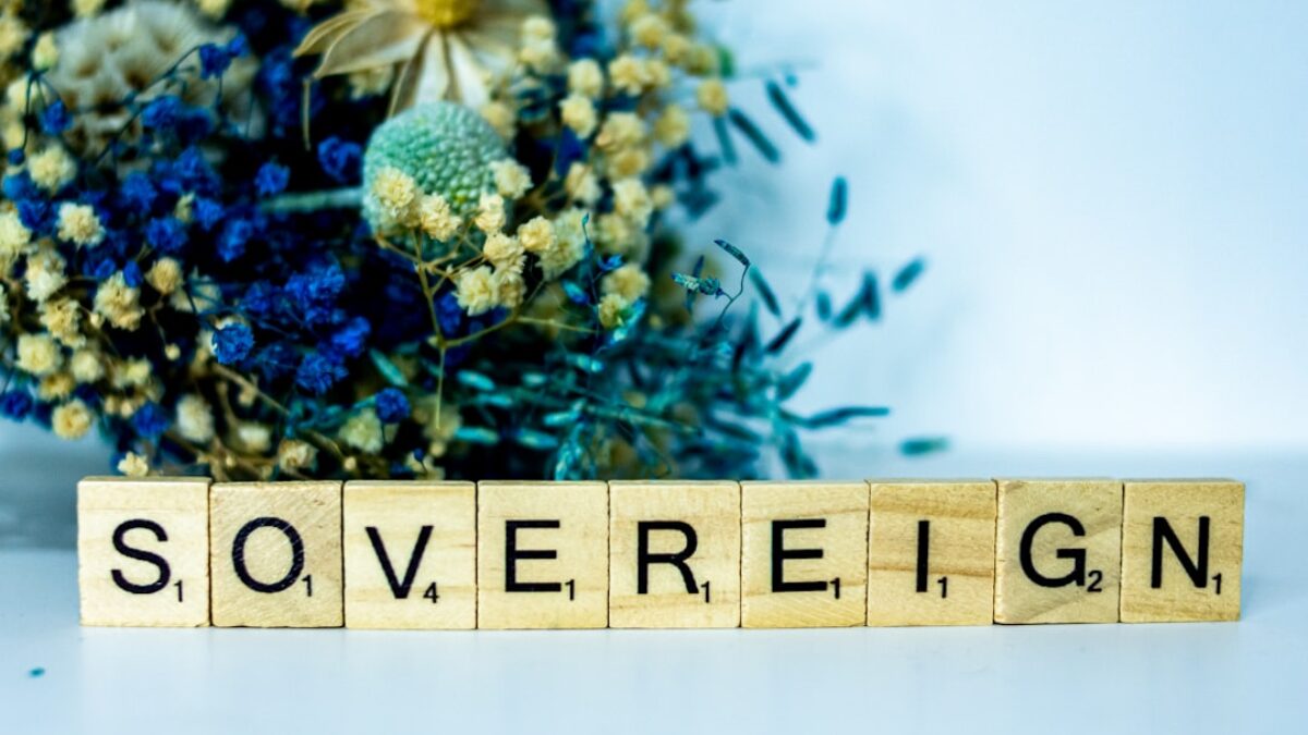 a wooden block that says sovereignn next to a bouquet of flowers