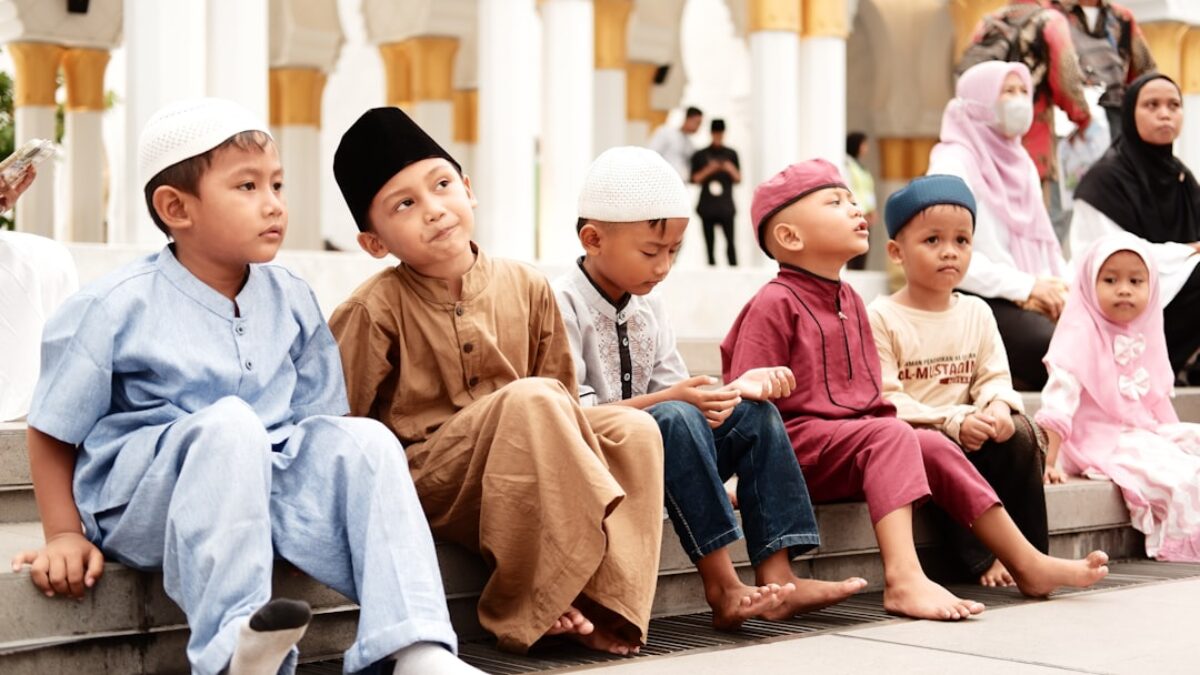 a group of children sitting on a ledge