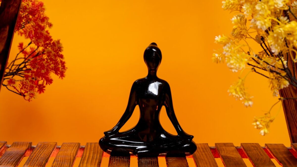 a black buddha statue sitting on top of a wooden table