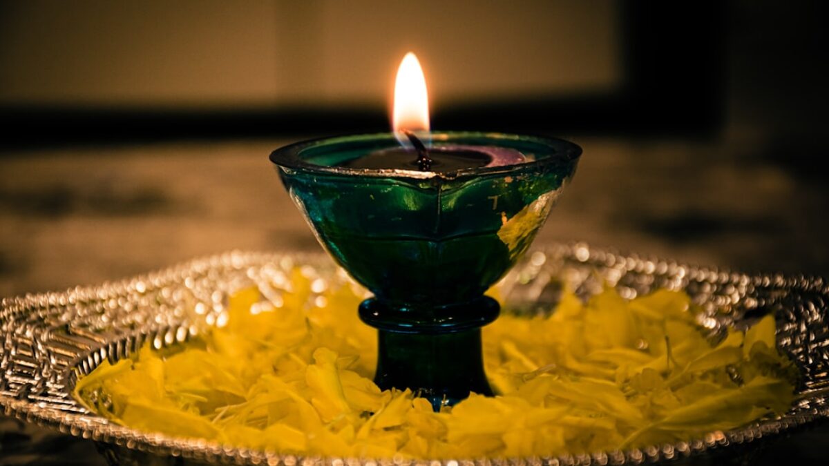 lighted candle in green glass holder