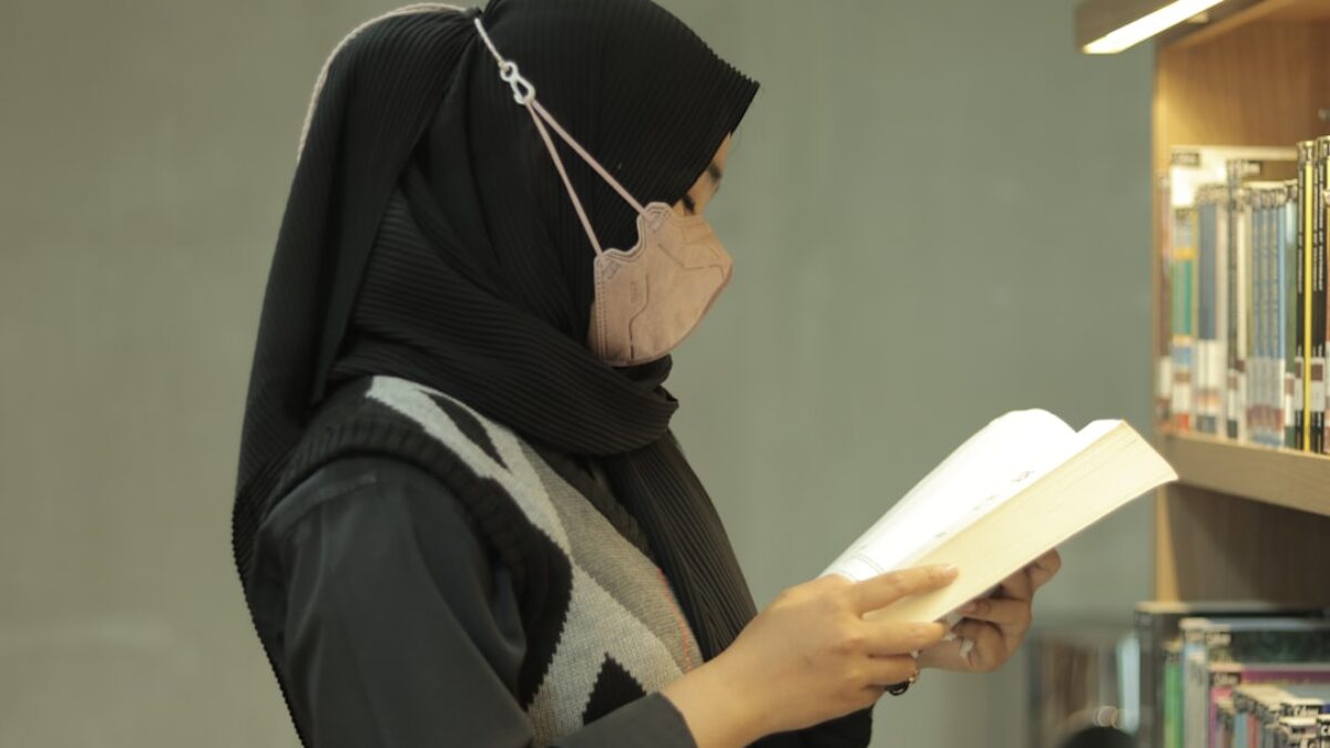 A woman reading a book in a library