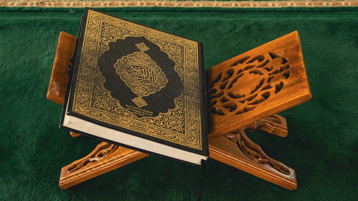 An open book sitting on top of a wooden stand